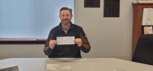 Mayor Tyler Nelson photographed with the $,1000 check from the Blue Cross of Idaho Foundaiton for Health. 